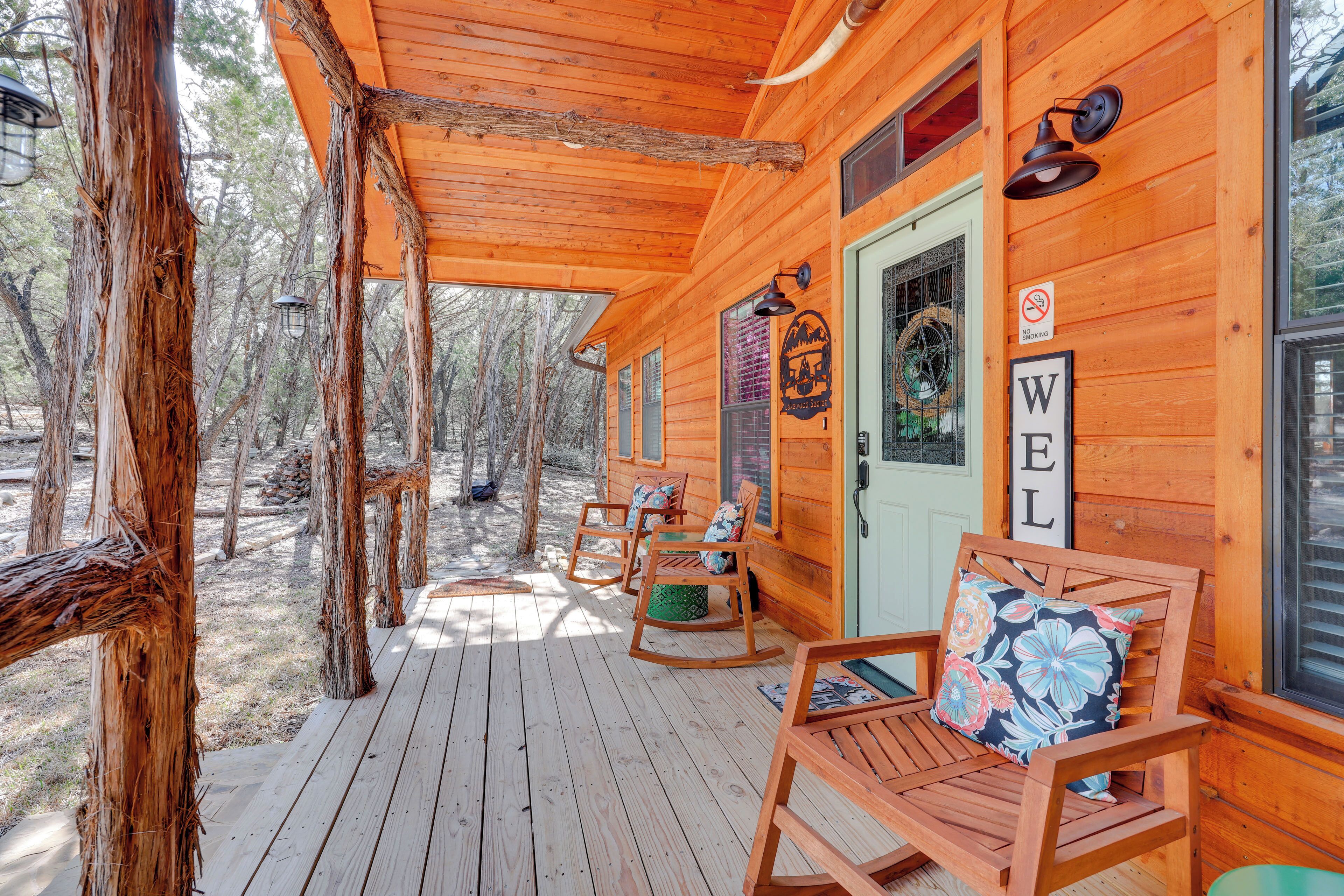 A wooden cabin with a porch, rocking chairs, and a 'WELL' sign.