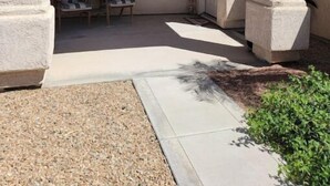 A covered patio area with a window, two chairs, and a door. - NEW! FAMILY FUN, ALOHA, Tropical Jericho with POOL (Lake Havasu City)