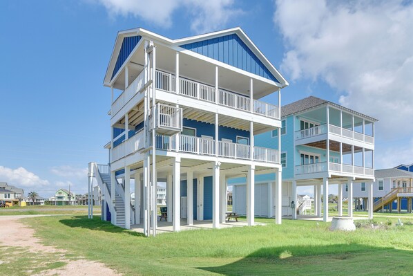 A two-story beachfront house with multiple balconies and a covered porch area. - Ocean Views, Steps to Sand! Coastal Galveston Gem (Galveston)