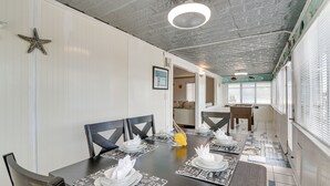 A dining area with a long table set for four, featuring black chairs and white placemats with black text. - Waterfront Galveston Bay Retreat - 4 Mi to Beach! (Galveston)
