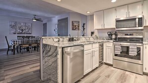 A modern kitchen with white cabinets, stainless steel appliances, and a marble countertop. - Brian Head Ski-in/ski-out Condo w/ Resort Perks! (Brian Head)