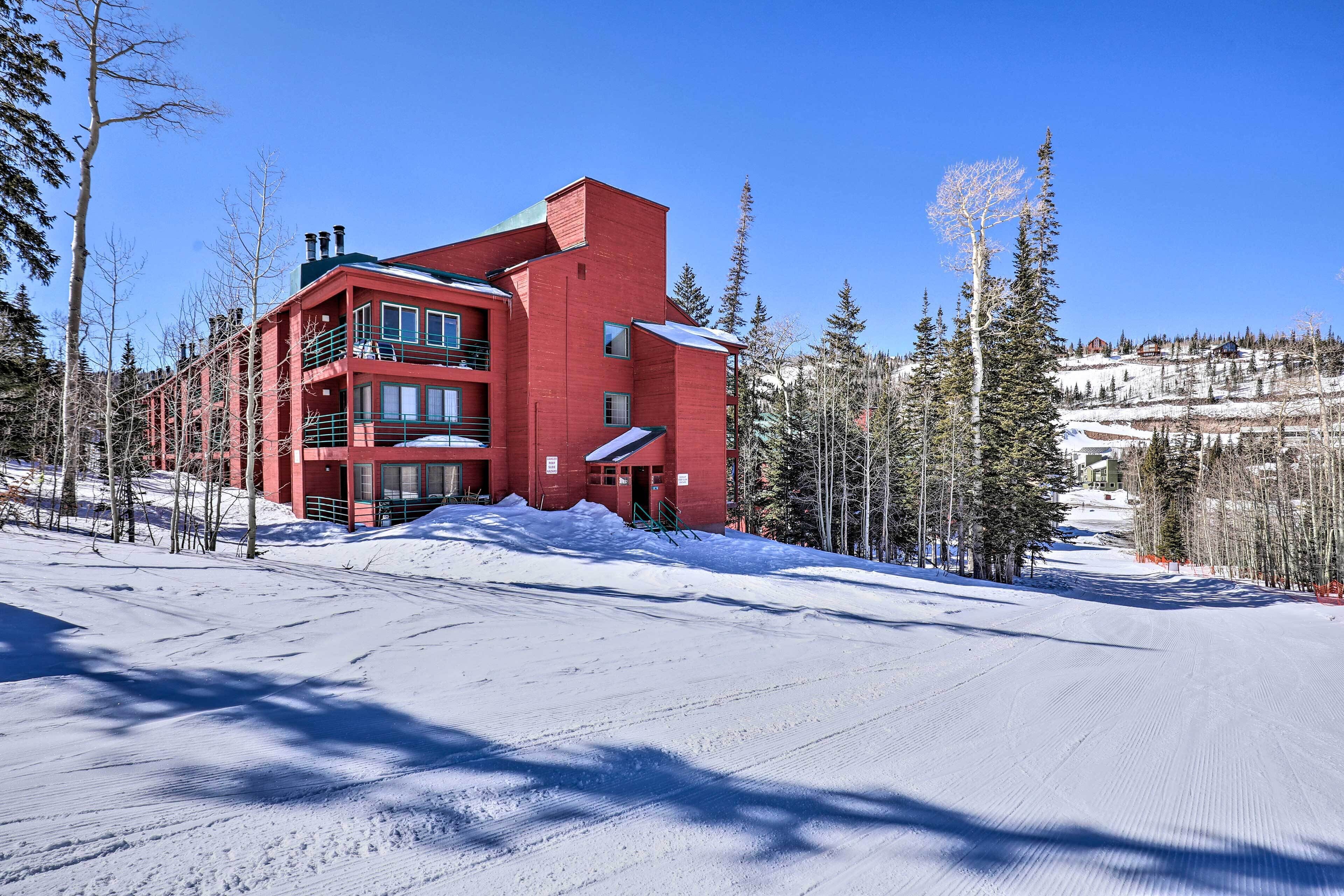 A red building with multiple floors, surrounded by snow-covered ground and trees.