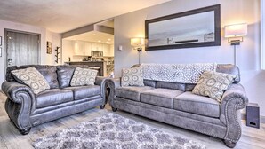 A living room with two leather sofas, a fluffy rug, and a large mirror. - Brian Head Ski-in/ski-out Condo w/ Resort Perks! (Brian Head)