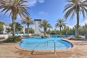 A swimming pool with palm trees and lounge chairs, surrounded by a building with a white facade. - Upscale Santa Rosa Beach Vacation Rental! (Santa Rosa Beach)