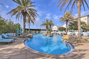 A pool area with lounge chairs and palm trees. - Upscale Santa Rosa Beach Vacation Rental! (Santa Rosa Beach)