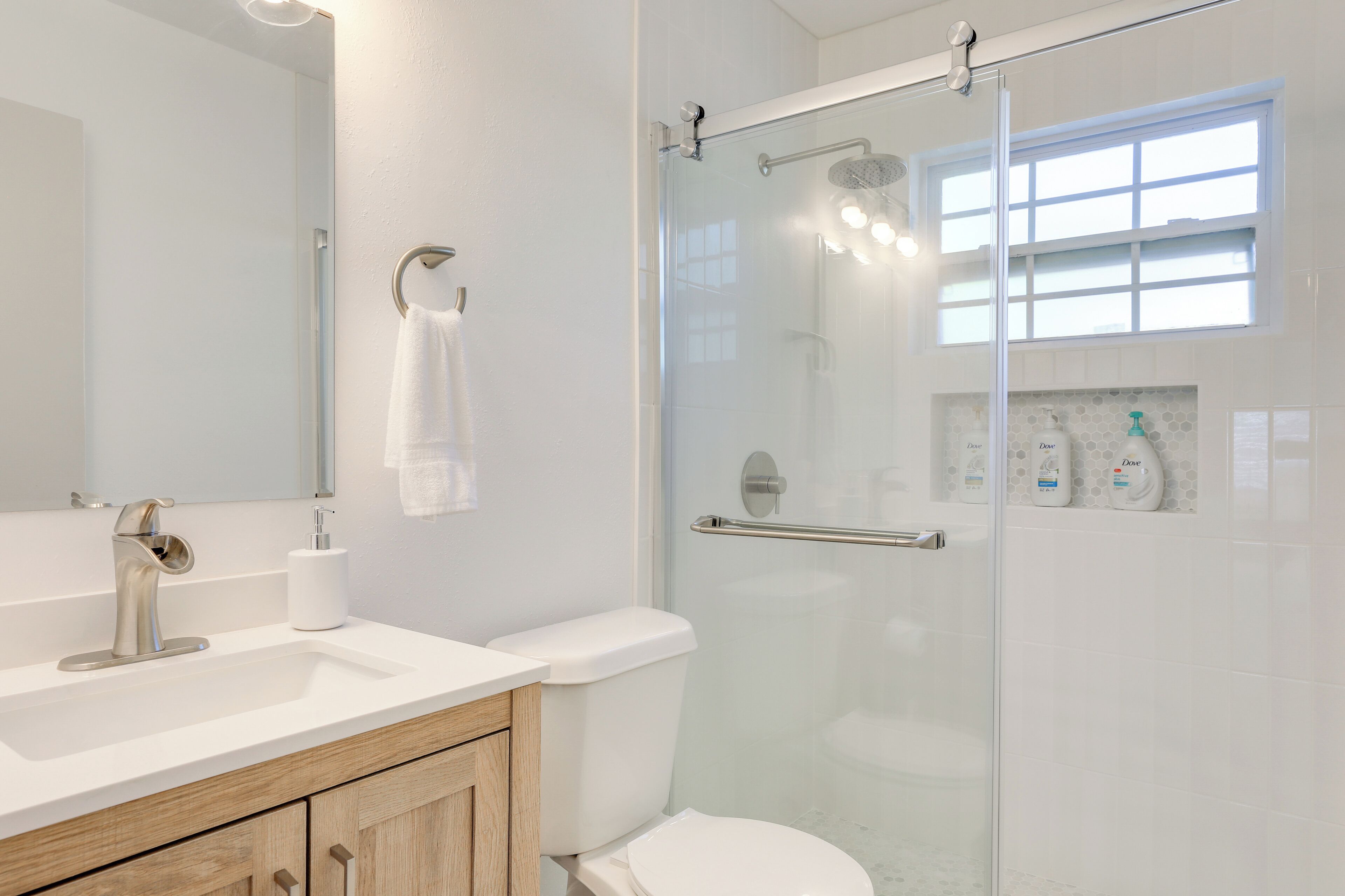Une salle de bain moderne avec une douche à parois de verre, un lavabo blanc et des toilettes.
