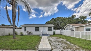 A single-story mobile home with a front porch, a small lawn, and a palm tree. - Central Sarasota Home: 8 Mi to Siesta Key! (Sarasota)