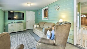 A living room with a sofa, armchairs, a TV, and a cabinet. - North Port Escape w/ Pool ~ 12 Mi to Beach! (North Port)