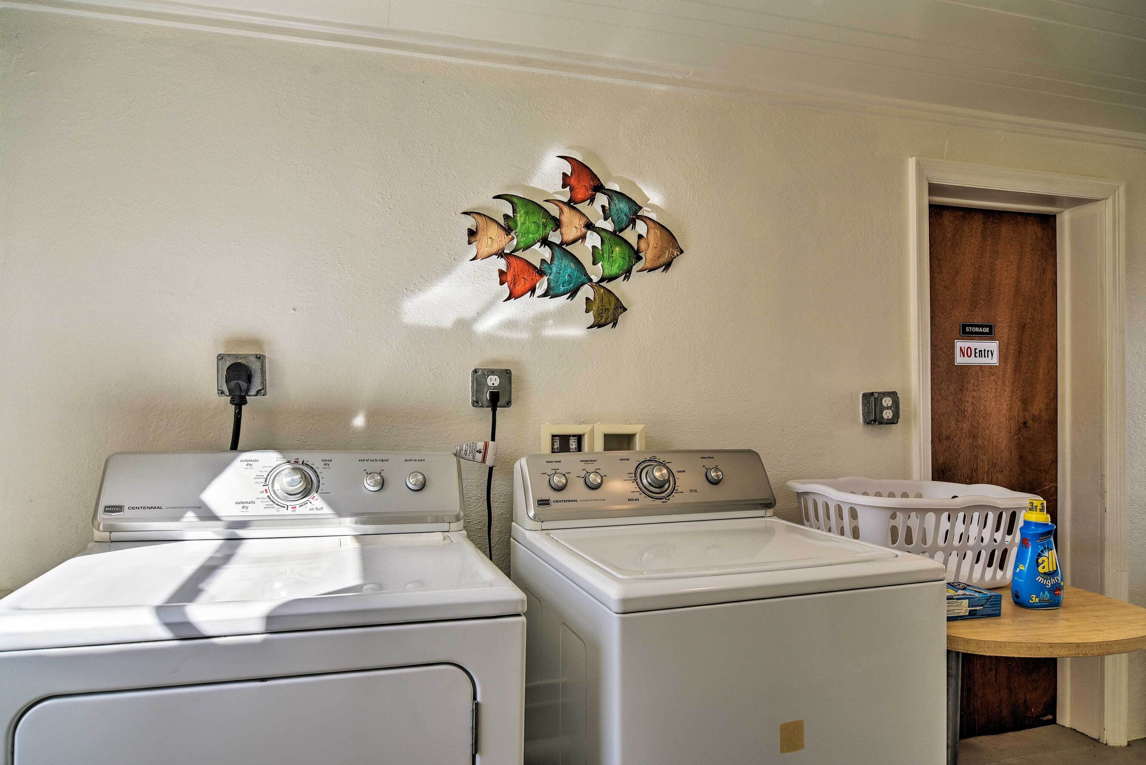 A laundry area with two washing machines, a wall-mounted drying rack, and a door with a 'No Entry' sign.