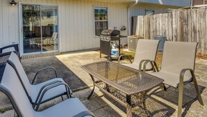 A patio with a grill, chairs, and a table. - Breezy Fort Walton Townhome ~ 5 Mi to Beach! (Fort Walton Beach)