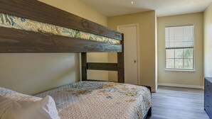 A bedroom with a bunk bed, a door, a window, and a dresser. - Breezy Fort Walton Townhome ~ 5 Mi to Beach! (Fort Walton Beach)