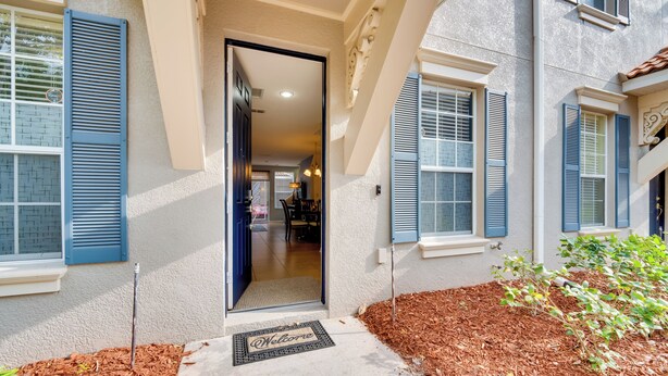 A house with a welcoming entrance, a visible interior with a dining area, and a well-maintained front yard.