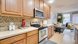 A kitchen with wooden cabinets, a microwave, a toaster, and a coffee maker.