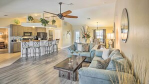 A spacious living area with a kitchen, a ceiling fan, and a dining area. - Lanai & Heated Pool: Stunning Cape Coral Getaway (Cape Coral)
