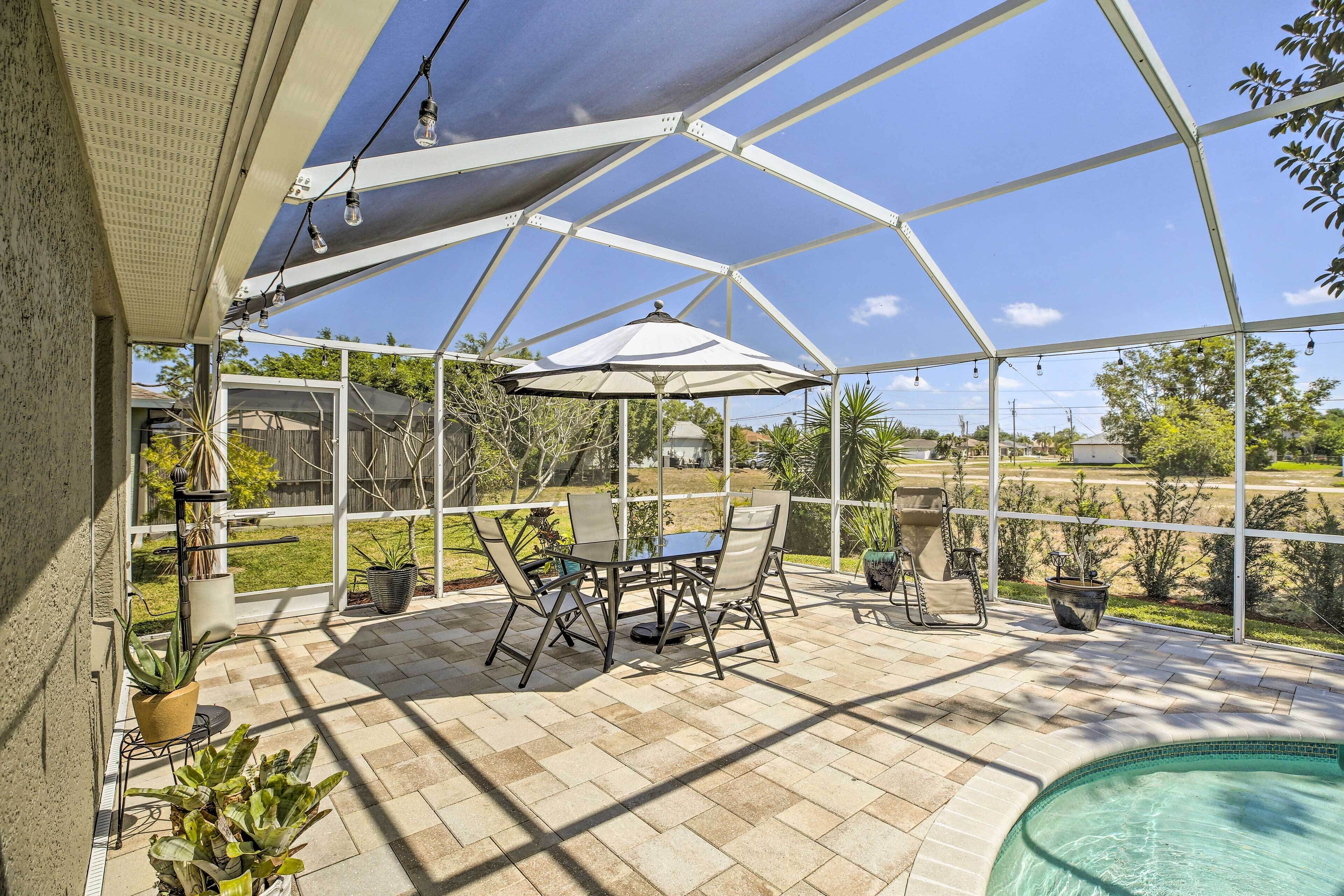 Un patio cubierto con piscina, mobiliario exterior y plantas en macetas.