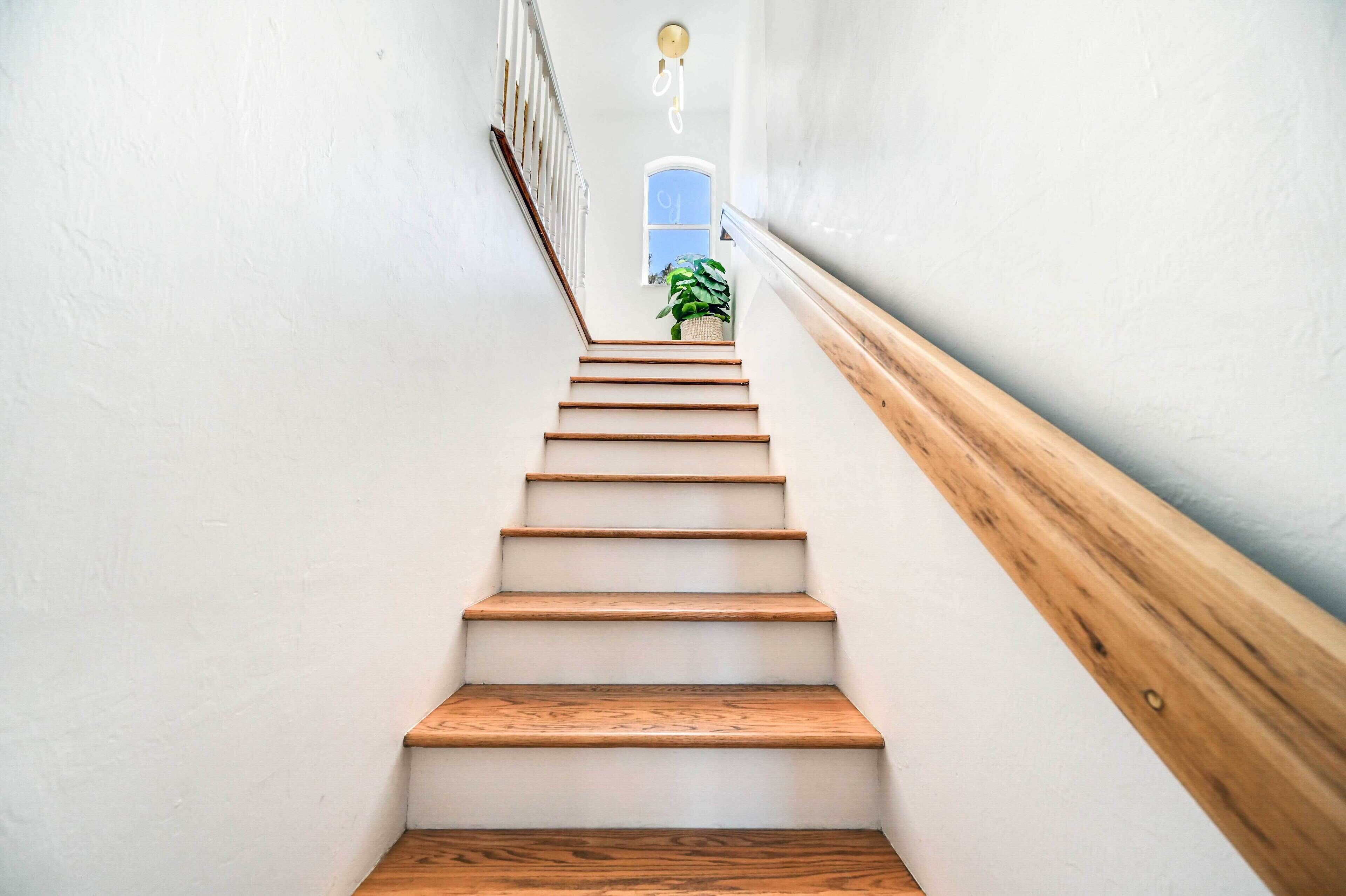 Un escalier avec des marches en bois et un mur blanc.