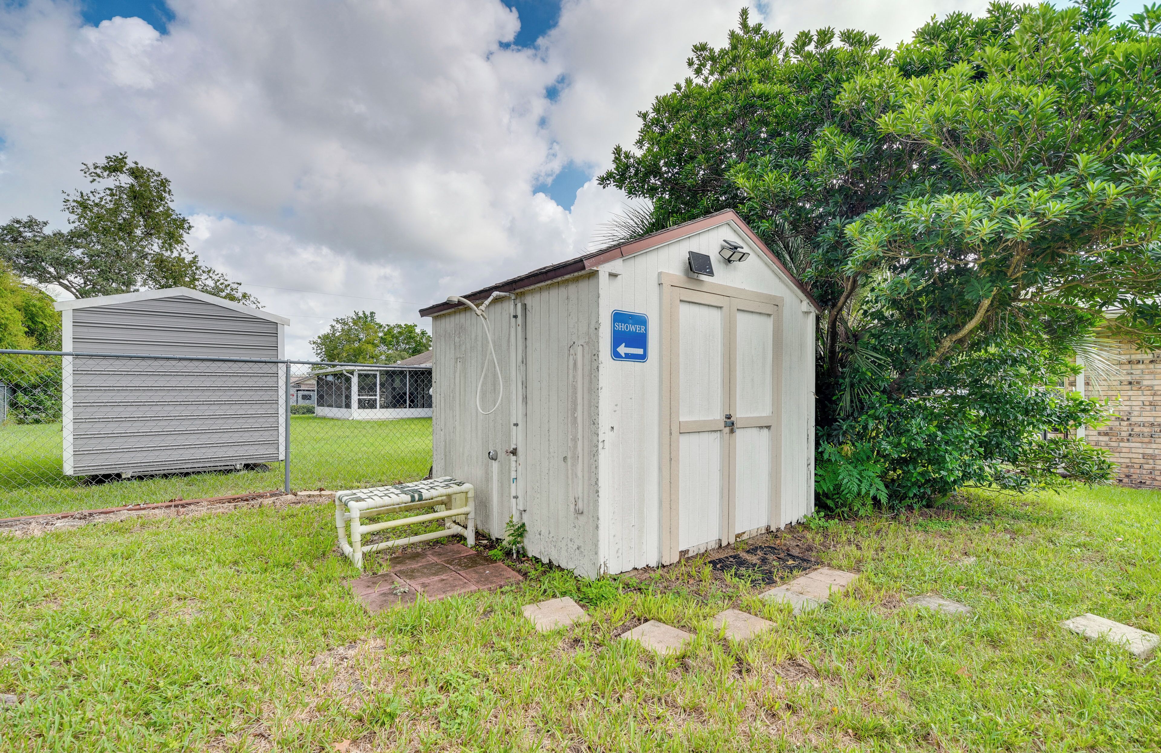 A small, single-story shed with a blue sign indicating a shower.