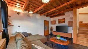 A modern living room with a wooden ceiling, a large sofa, a TV, and a staircase. - Amazing home in Vitesinec with sauna (Vitesinec)