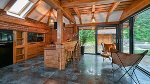 A kitchen with a central island, wooden cabinets, and a large window. - Amazing home in Vitesinec with sauna (Vitesinec)