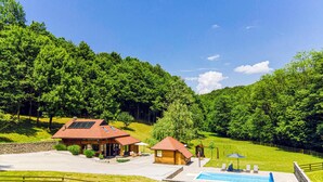 A resort with a swimming pool, wooden cabins, and a stone wall. - Amazing home in Vitesinec with sauna (Vitesinec)