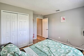 A bedroom with a bed, a wardrobe, and a door leading to another room. - Family-friendly Home ~ 6 Mi to Beach or Golf (Edgewater)