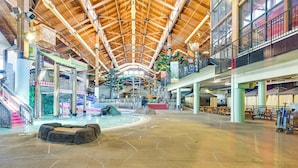 A spacious indoor area with a high wooden ceiling, a central water feature, and multiple levels with seating areas. - Resort Cabin w/ Lake Access in Central Warrens! (Warrens)