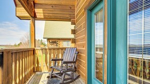 A wooden deck with a rocking chair and a door with a window. - Resort Cabin w/ Lake Access in Central Warrens! (Warrens)