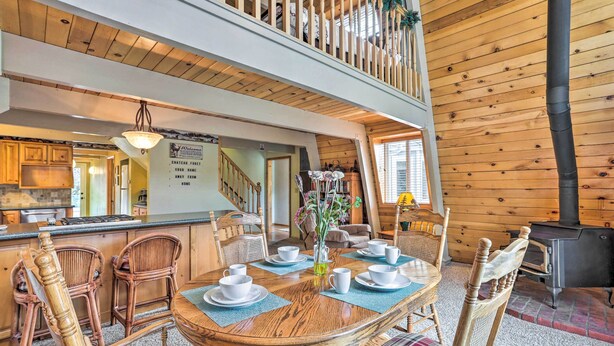 Un interno in legno con zona pranzo, cucina e una scala.