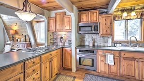 Una cucina moderna con mobili in legno, elettrodomestici in acciaio inossidabile e una grande isola.