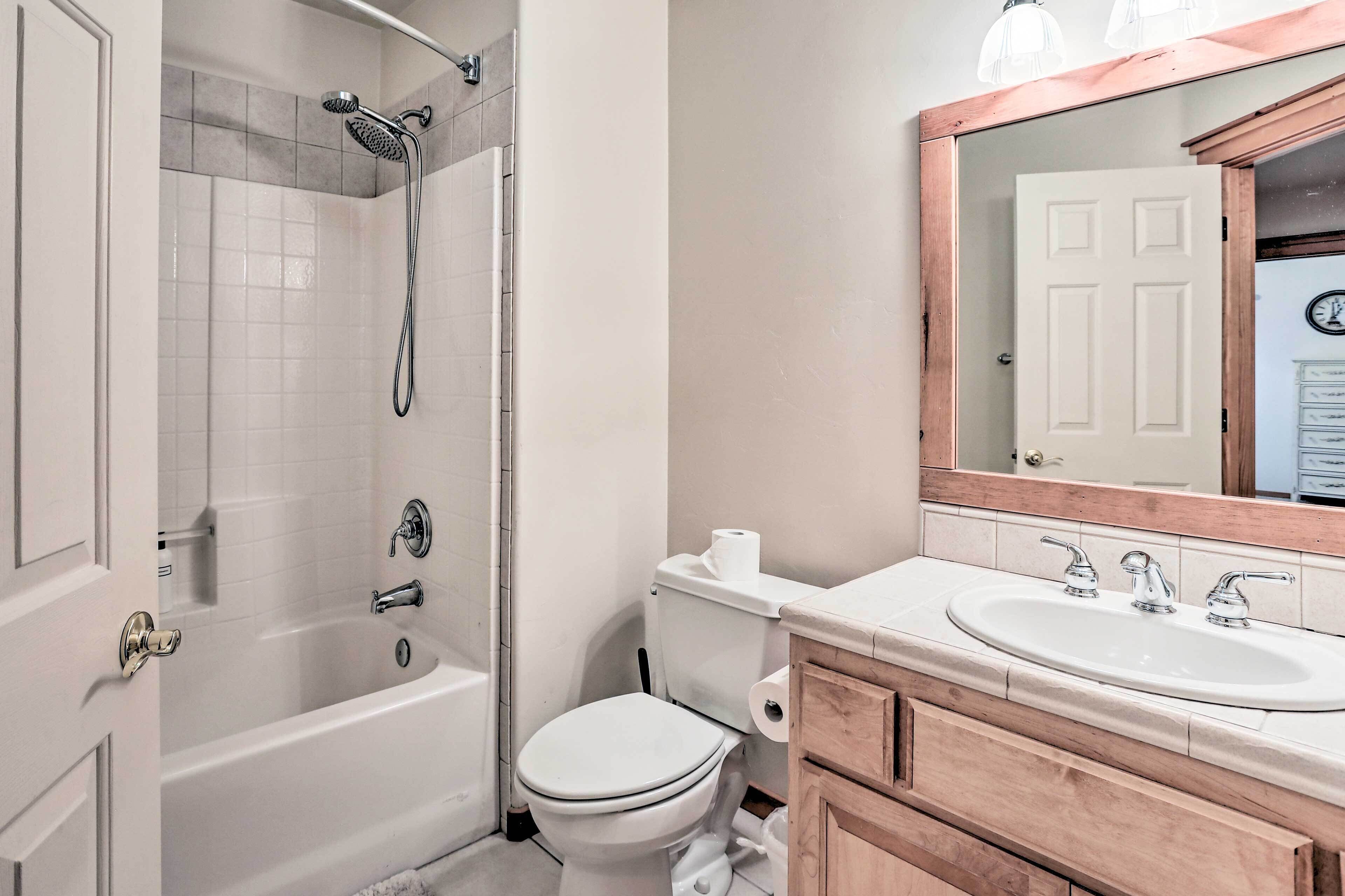 A bathroom with a bathtub, toilet, and sink.