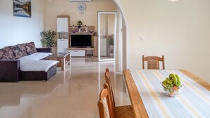 A living room with a sofa, TV, and a dining area with a table set for two. - Gorgeous apartment in Starigrad with WiFi (Starigrad)