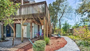Une terrasse en bois avec une maison en arrière-plan.