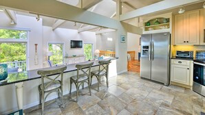 Cozinha espaçosa com uma ilha grande, eletrodomésticos embutidos e muita luz natural.