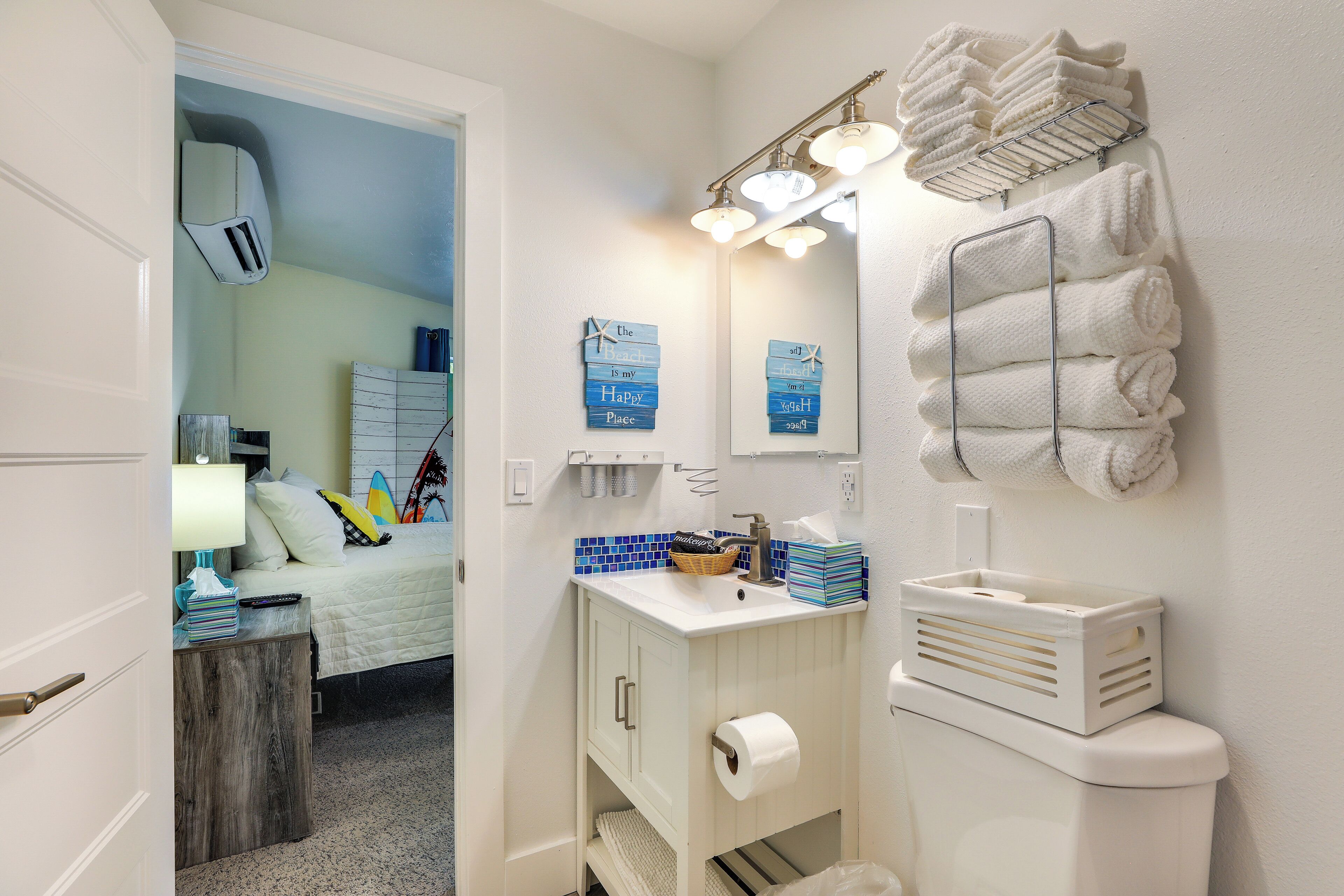 A bathroom with a white sink, a mirror, a towel rack, and a toilet.