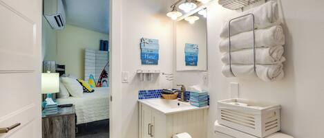 A bathroom with a white sink, a mirror, a towel rack, and a toilet.