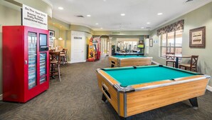A pool table area with a red rental DVD machine, a pool table, and a table tennis table. - Resort Condo in Kissimmee ~ 3 Mi to Disney! (Kissimmee)
