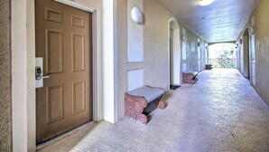 A hallway with a brown door, a bench, and a light fixture. - Resort Condo in Kissimmee ~ 3 Mi to Disney! (Kissimmee)