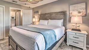 A bedroom with a bed, bedside tables, a ceiling fan, and a painting on the wall. - Well-appointed Family Condo on Miramar Beach! (Miramar Beach)