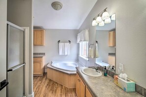 A modern bathroom with a bathtub, a sink, and a large mirror.