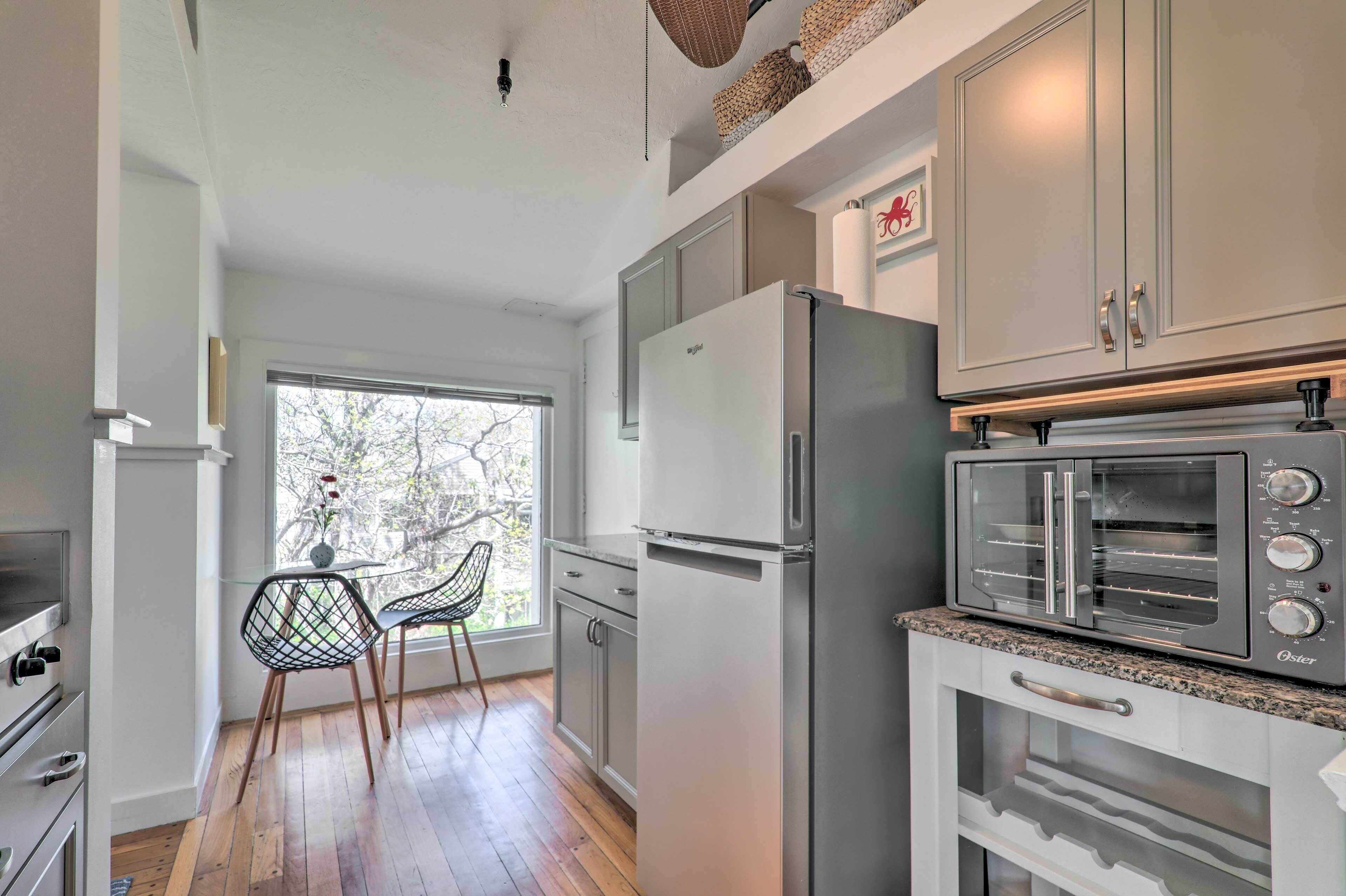 Una cocina moderna con horno empotrado, refrigerador y microondas.