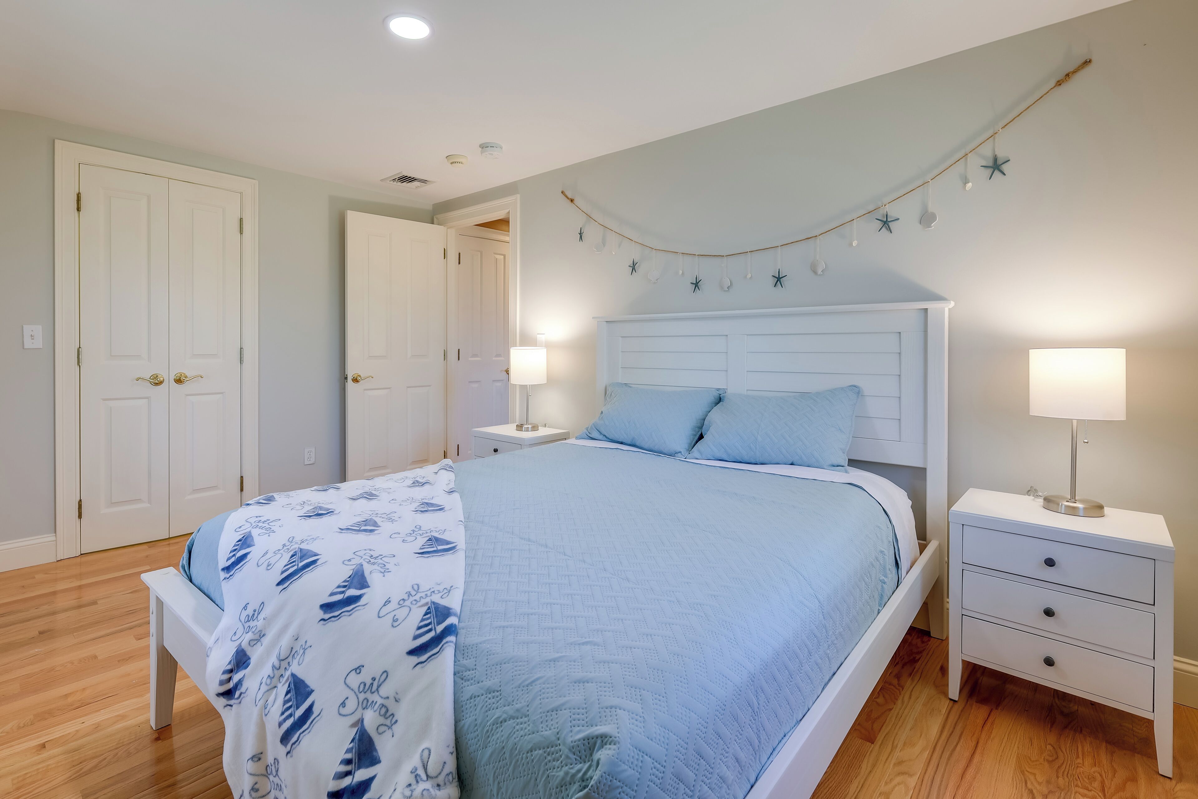 A bedroom with a bed, nightstands, and a wardrobe.