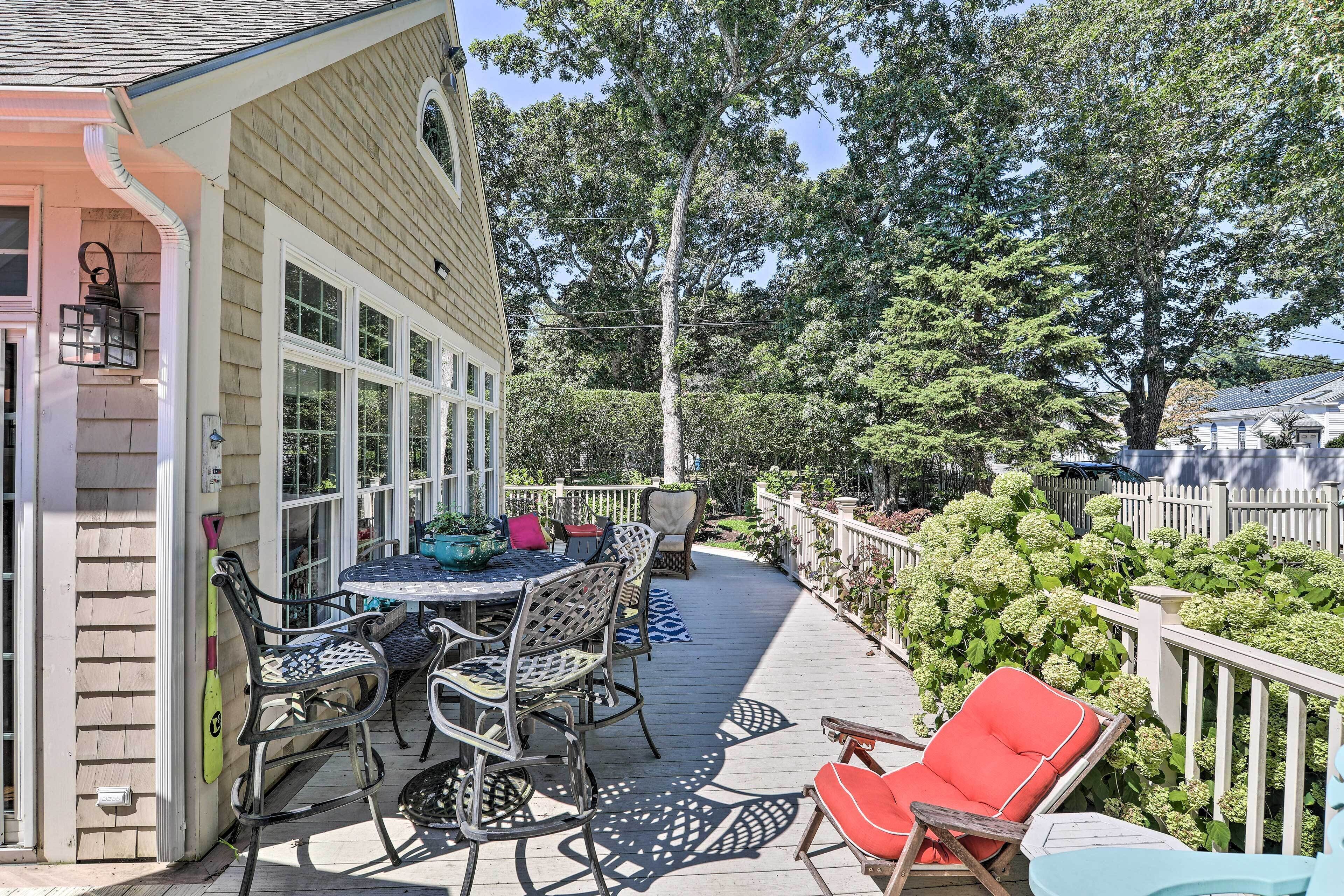 A deck with outdoor furniture, a table, and chairs.