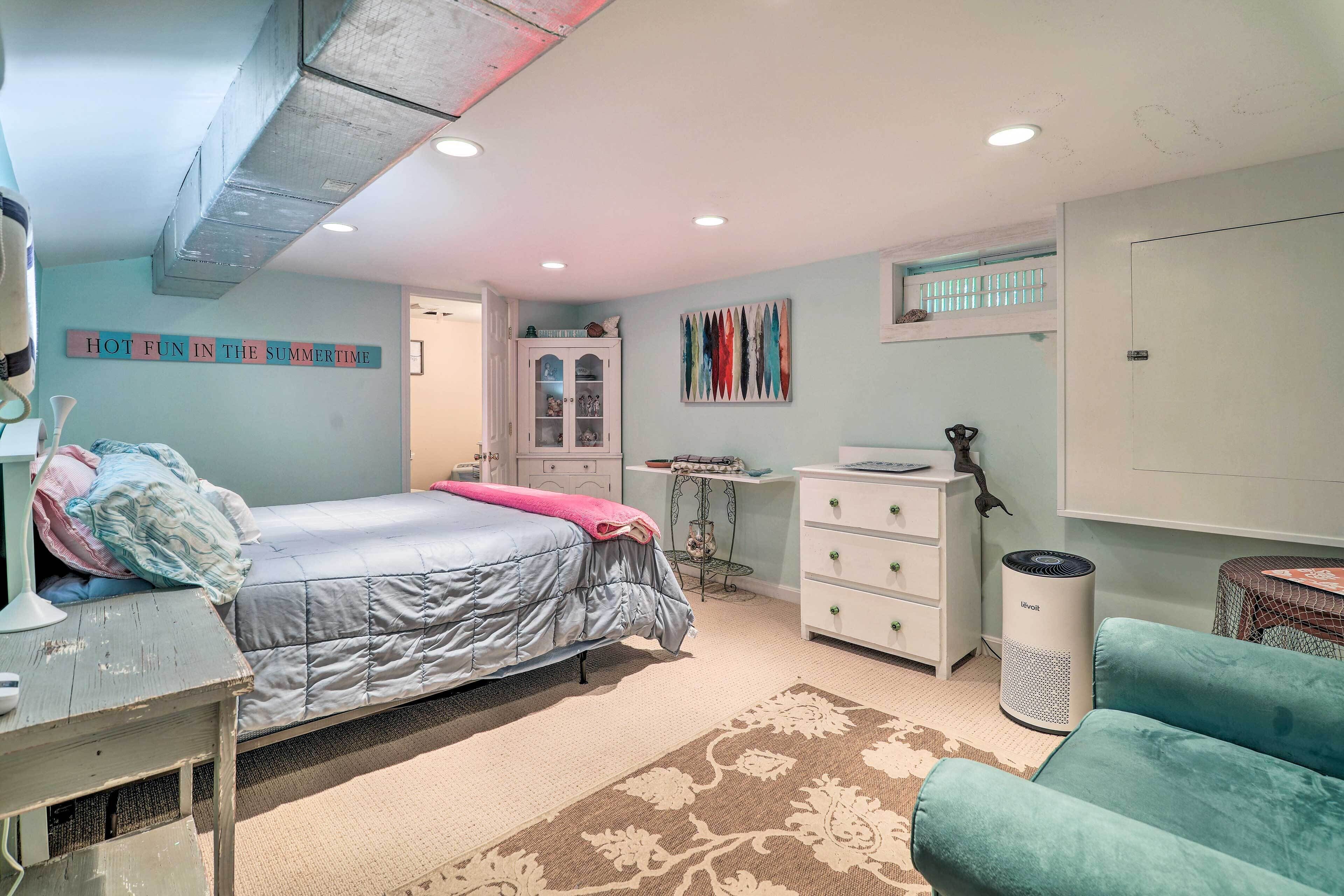 A bedroom with a bed, dresser, desk, and chair.