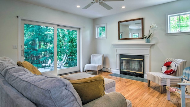 A living room with a sofa, armchair, and a fireplace.