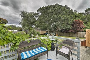 A covered patio with wicker furniture and a view of the backyard. - West Yarmouth Home w/ Deck < 2 Mi to Beach! (West Yarmouth)