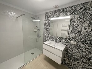 Chuveiro, secador de cabelo, toalhas de banho, papel higiênico