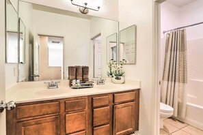 A bathroom with a wooden vanity, a large mirror, a sink, and a shower curtain. - Welcoming Coachella Home w/ Heated Salt Pool! (Coachella)