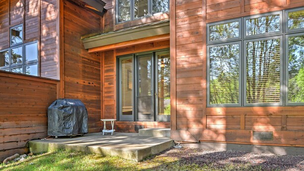 A wooden cabin with large windows, a covered grill, and a small table. - Forest-view Gem 2 Mi to Diamond Peak Ski Resort! (Incline Village)