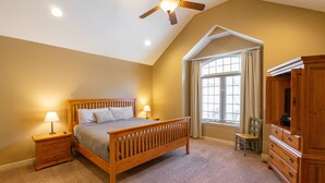 A bedroom with a wooden bed, nightstands, a dresser, a chair, and a window with curtains. - Deer Valley 164 (Branson)