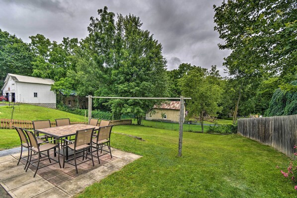 A patio with a table and chairs, surrounded by a grassy yard and trees. - Penn Yan Escape w/ Yard, 1 Mi to Keuka Lake! (Penn Yan)